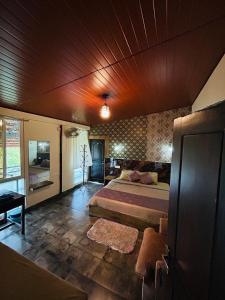 um quarto com uma cama grande e um tecto de madeira em Coorg Sana Riverside em Suntikoppa mais 37 fotografias