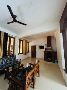 uma sala de estar com uma ventoinha de tecto e uma lareira em Coorg Sana Riverside em Suntikoppa