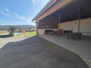a pavilion with two tables and a patio with a view at Hébergement Cressia in Cressia