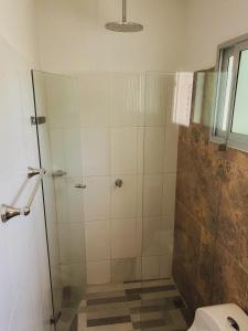 a bathroom with a glass shower with a toilet at Surfer Grill, alojamiento en puerto Colombia, pradormar, Habitación Suite in Pradomar