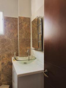 a bathroom with a glass sink and a mirror at Surfer Grill, alojamiento en puerto Colombia, pradormar, Habitación Suite in Pradomar