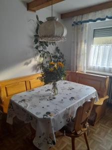 a dining room table with a vase of flowers on it at FEWO Prackenbach in Prackenbach