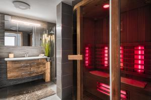 a bathroom with a sink and a shower with red lights at Panoramic View Cottage House - Private Wellness Retreat in Hočko Pohorje