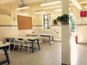 una classe con tavoli, sedie e lavagna di YHA Ngong Ping SG Davis Youth Hostel a Hong Kong