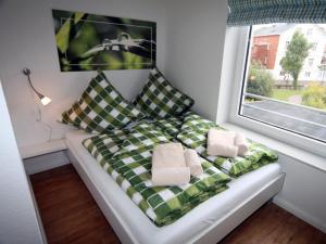 a bed sitting in a room with a window at Jantje in der Villa Patricia in Borkum