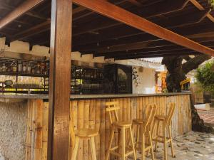 a bar with wooden stools in front of it at Surfer Grill, alojamiento en puerto Colombia, pradormar, Habitación Suite in Pradomar +3 photos