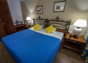 a bedroom with a large blue bed with yellow pillows at Topaz Hotel in St Paul's Bay