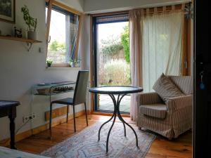 a living room with a table and a couch at Chambre avec terrasse Chez Anne in Rennes