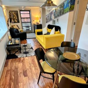 a living room with a yellow couch and chairs at New Forest Fordingbridge - Art Deco Unique Apartment in Fordingbridge +5 photos