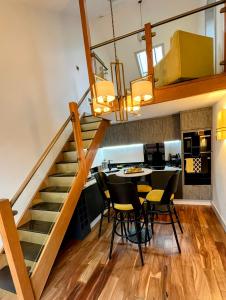 a room with a staircase and a table and chairs at New Forest Fordingbridge - Art Deco Unique Apartment in Fordingbridge