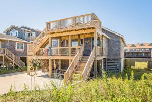 a large wooden house with stairs in front of it at The TARDIS in Kitty Hawk