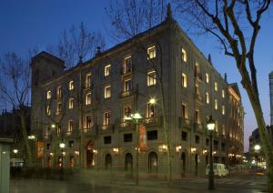 a large building is lit up at night at Hotel 1898 in Barcelona