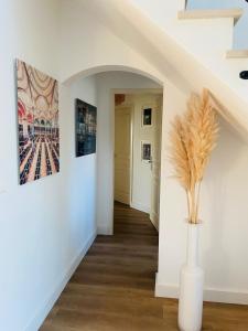 a hallway with white walls and a vase with a plant at Nice villa with a view in Saint-André-de-Cubzac +17 photos
