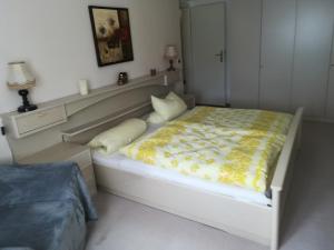 a bedroom with a bed with a yellow blanket on it at schnuggliche Ferienwohnung in Eppendorf