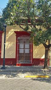 a red door on a building with a tree at Alojamiento en el Centro Histórico in Oaxaca City