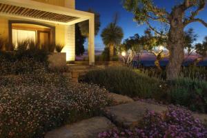 a house with a tree and flowers in front of it at Castellabate House in Santa Maria di Castellabate