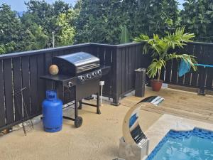a grill on a patio next to a swimming pool at Finn Room - Ferdie's Place in Port Antonio
