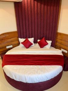 a bed with two red pillows in a room at hotel r k VILLA in Ahmedabad