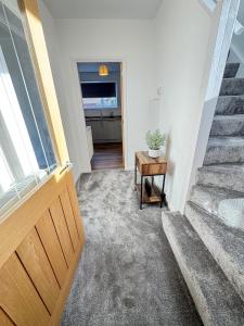 a hallway with a door and a table and stairs at Luxury 3 bed home in central Thurso - NC500 in Thurso