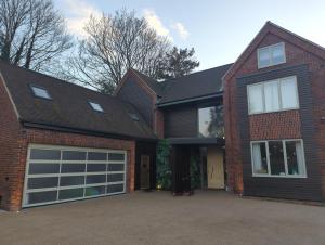a red brick house with a garage at The Nest at Fairfield in Wargrave