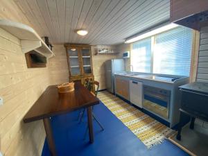 a small kitchen with a table and a refrigerator at Loft in the forest in Boliden