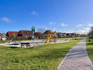 a park with a playground and a slide at Ferienhaus Inselkieker in Neßmersiel