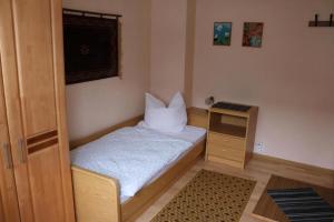 a small bedroom with a bed and a small cabinet at Haus Budinger in Alf