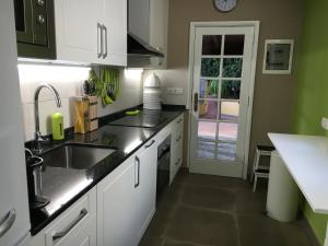 a kitchen with white cabinets and a sink at Los Jazmines in Agaete