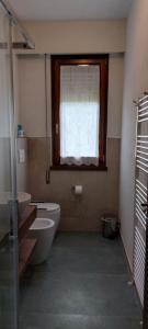 a bathroom with a sink and a toilet and a window at Flache Linde in Terranuova Bracciolini
