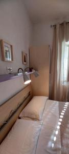 a bedroom with a bed with a lamp and a mirror at Zwei Zimmer Penthouse Wohnung Mit Terrasse Mit Meerblick in Peschici