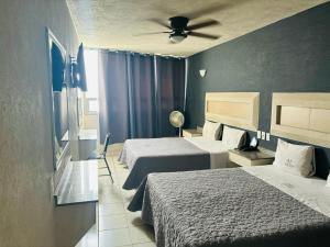 una camera d'albergo con due letti e un ventilatore a soffitto di Hotel Union Guadalajara a Guadalajara