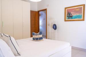 Un dormitorio blanco con una cama blanca y un espejo. en BlueMary, en Giardini Naxos