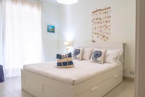 1 dormitorio blanco con 1 cama blanca grande con almohadas en BlueMary, en Giardini Naxos