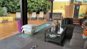 a patio with a couch and a table and chairs at Los Jazmines in Agaete +32 photos