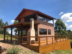 una casa con un porche envolvente con chimenea en Villa Cambara, en Cambará