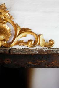 a gold mask sitting on top of a wooden table at Casa Il Sàrperi In Montecatini Val Di Cecina in Montecatini Val di Cecina