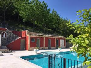 una piscina frente a una casa con árboles en Ferienhaus Casa Sacciofa In Monte Rinaldo, en Monte Rinaldo