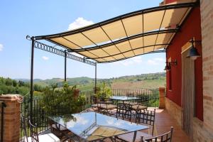 Un patio con mesas y sillas bajo toldo. en Ferienhaus Casa Sacciofa In Monte Rinaldo, en Monte Rinaldo