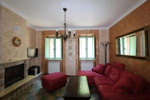 Una sala de estar con un sofá rojo y un televisor. en Ferienhaus Casa Sacciofa In Monte Rinaldo, en Monte Rinaldo 19 fotos más