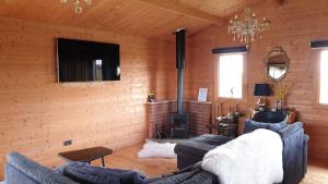 a living room with two couches and a fireplace at Graystock Lodge in Lancaster
