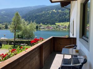 balcón con mesa, sillas y vistas al lago en Wohnung Mit Balkon Und 2 Schlafzimmer, en Feld am See
