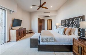 カボ・サン・ルーカスにあるOceanfront 3BR Condo at Diamante by The Agency Bajaのベッドと薄型テレビのある寝室