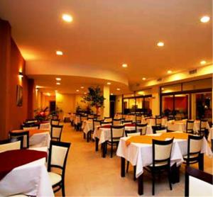 a restaurant with tables and chairs with white tablecloths at Hotel Nuevo Mundo in San Rafael
