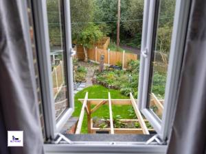a view of a garden from an open window at Calder Canal by Alt-Stay - Peaceful 3 Bed Canal Side Cottage Contractor and Relocation Accommodation Wakefield with Stunning Views, Parking, Kitchen, Laundry, Smart TV and Wi Fi - Weekly and Monthly Rates in Wakefield