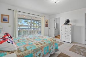 a bedroom with a bed and a large window at Island Sunrise - Pet friendly, waterfront duplex! in Deep Hole