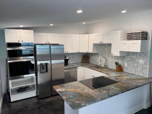 een keuken met witte kasten en een roestvrijstalen koelkast bij Castaway on Treasure Island NPR in New Port Richey +13 foto's