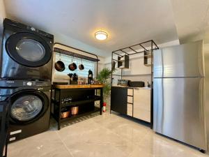 a kitchen with a stainless steel refrigerator and a washer at Mont Résidence offering a Loft and 3 Bedroom Apartment steps from the ferry in Vieques