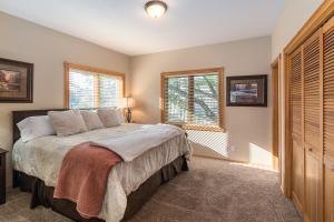 a bedroom with a bed and two windows at THE INN Bigfork Bay in Bigfork