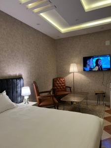 a hotel room with a bed and a flat screen tv at Malath Furnished Units-ملاذ للوحدات المفروشة 2 in Tabuk +11 photos