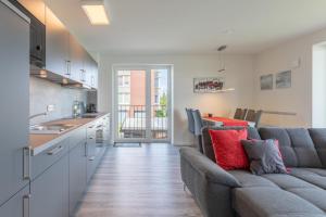 a living room with a couch and a kitchen at Auszeit am Deich in Nordstrand
